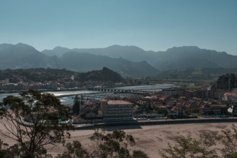 Scenic view of a coastal town in Asturias with mountains in the background, Spain.