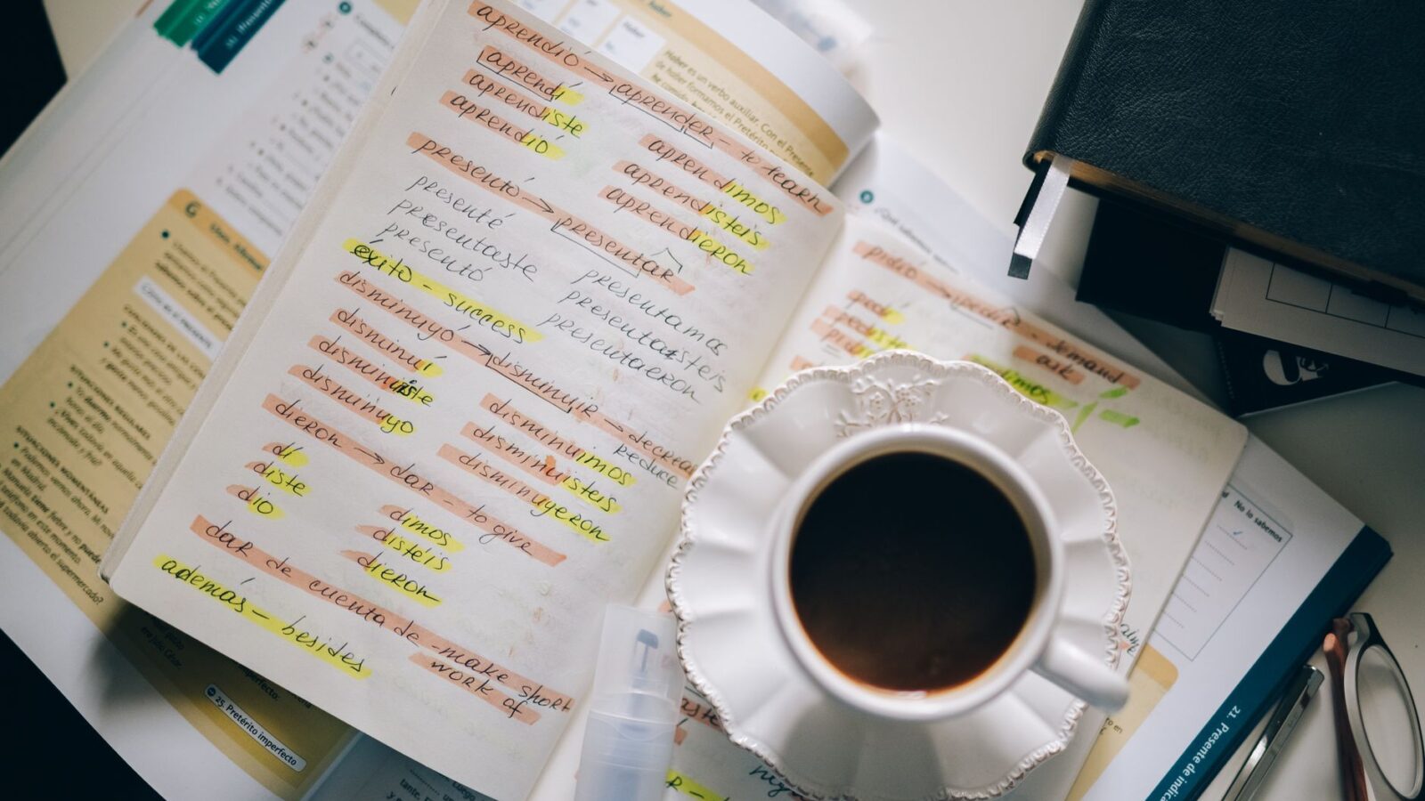 A cup of coffee on handwritten Spanish notes for language learning inspiration.
